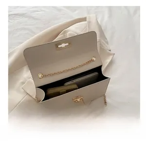 Vue détaillée de l'intérieur du sac crème avec chaîne, montrant le rangement du mobile