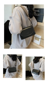 Detailed view of black PU leather crossbody bag featuring a vintage jacquard wide strap