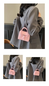 Detail view of pink PU leather handbag with silver hardware and metal chain strap