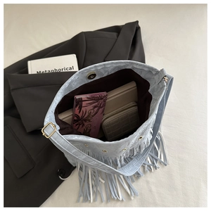 Dettaglio della borsa a secchiello celeste con frange e chiusura magnetica interna