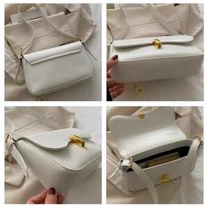 Detailed view of white minimalist handbag with gold metal lock and internal storage space
