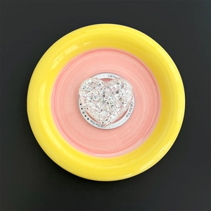 Close-up of heart-shaped glitter phone grip with Gift For You print on a round base