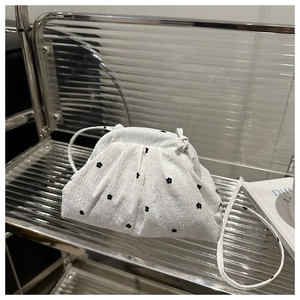 Détail du sac nuage plissé blanc avec de délicats motifs floraux noirs et texture en nylon
