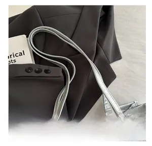 Detail of silver tote bag featuring butterfly patterns and durable long shoulder straps
