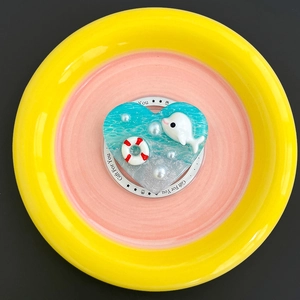 Detail view of heart-shaped ocean-themed phone grip with dolphin, lifering and pearls