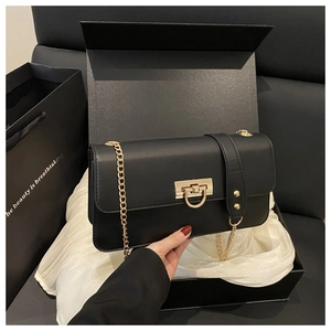 Luxury black shoulder bag with gold hardware presented in a premium gift box with bag