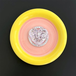 Macro shot of glittery heart phone socket with Gift For You text on a ceramic tray