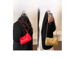 Chic mini tote bag with metal bow charm shown in red and gold in two carrying styles