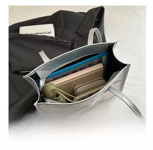 Top view of spacious interior of silver embroidered tote bag with daily essentials