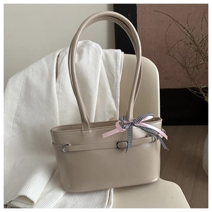 Détail du sac cabas beige en similicuir avec boucle argentée et nœud en ruban rose