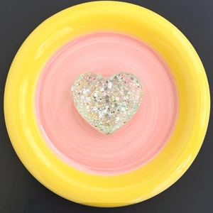 Macro detail of heart-shaped glitter phone grip with sequins and clear resin texture