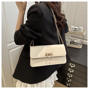 Detail of a creamy white crossbody bag showing the golden D-shaped clasp and chain strap