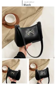 Detail of black PU leather shoulder bag with a gold bow hardware and top zipper closure