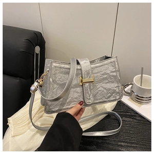 Detail of silver crinkled texture handbag with golden buckle and sleek leather strap