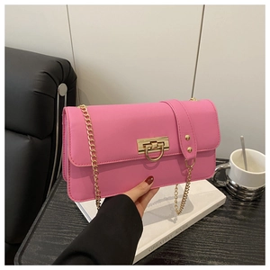 Detailed shot of pink leather crossbody bag with elegant gold chain and metal clasp