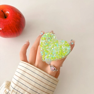Detail of heart-shaped phone grip with green glitter sequins and retractable base