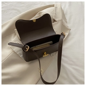 Detailed view of the dark brown matte leather handbag interior with a gold twist lock