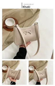 Detail of khaki shoulder bag featuring a decorative golden bow and sleek faux leather finish