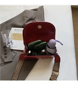 Detail of red leather saddle bag interior capacity with smartphones and umbrella