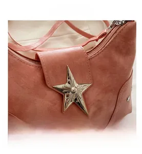 Detail of rose pink leather shoulder bag featuring a vintage metal star lock buckle