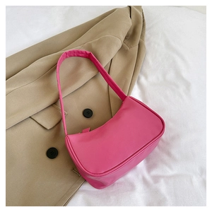 Detailed side view of hot pink matte PU leather mini shoulder bag on fabric background