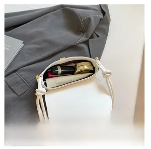Top view of white leather bag interior showing capacity for lipstick and makeup items