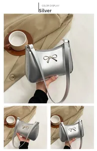 Detail of silver baguette bag with metallic PU leather and golden bow metal buckle