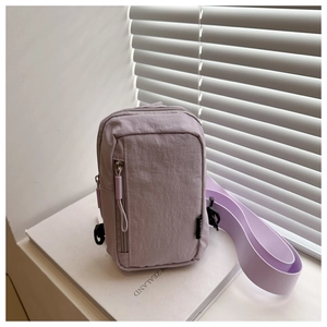 Close-up of lavender nylon crossbody bag with zipper pockets and Fashion woven label