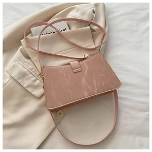 Detailed macro view of pink marble textured shiny leather handbag with metal buckle