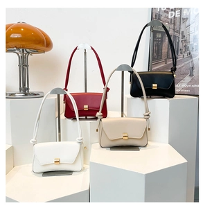 Group of four stylish baguette bags in white, red, cream, and black displayed in a boutique