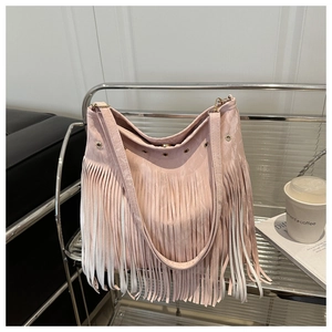 Dettaglio ravvicinato della borsa a tracolla rosa chiaro con frange e occhielli metallici
