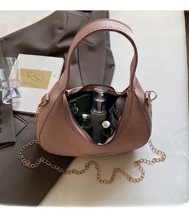 Interior view of pink crescent bag showing large capacity for essentials with chain strap