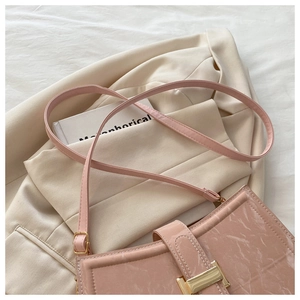 Detail of pink patent leather shoulder bag with marble texture and gold metal buckle