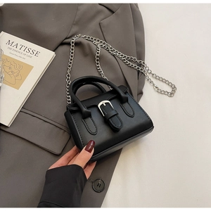 Détail d'un mini sac cabas noir avec boucle argentée et bandoulière chaîne chic