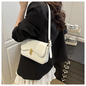 Chic white leather shoulder bag with gold metal clasp on model in minimalist interior