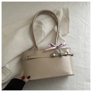 Détail du sac à main beige avec nœud rose et texture en cuir PU de haute qualité