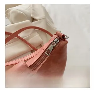 Detail showing smooth silver zipper and D-ring on coral pink faux leather bag