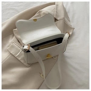 Top view of white leather crossbody bag interior showing storage space and gold hardware