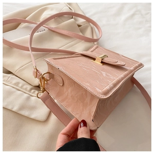 Detail of pink marble textured crossbody bag with gold metal buckle and shoulder strap