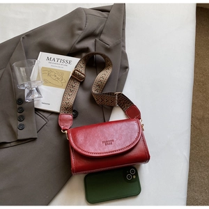 Detail of red vintage crossbody bag with jacquard strap and fashion bags embossed logo