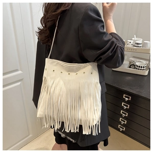 Dettaglio della borsa a spalla boho bianco sporco con lunghe frange e occhielli