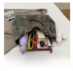 Top-down view of spacious grey canvas tote bag interior with everyday essentials and strap