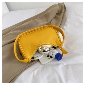 Interior view showing capacity of yellow crescent underarm bag with lipstick and phone