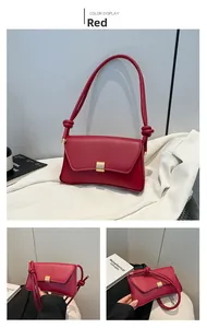Detail of red baguette bag featuring a knotted shoulder strap and golden metal buckle