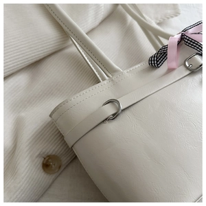 Détail du sac cabas blanc cassé avec cuir synthétique texturé et noeud décoratif