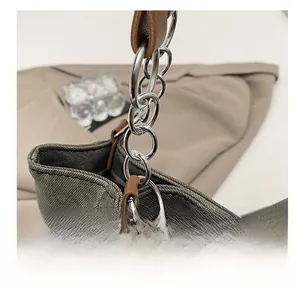 Close-up of premium silver metal rings connecting gray canvas and brown leather on tote bag