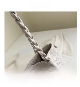 Detail view of beige woven tote bag showing premium texture and sturdy woven handles