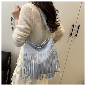 Dettaglio borsa hobo azzurra con occhielli metallici e lunghe frange decorative