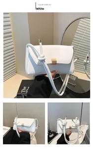Detail of white rectangle flap bag with gold buckle and stylish knotted shoulder strap