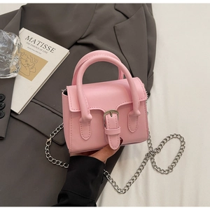 Detailed macro of pink mini square bag with silver chain strap and metal buckle